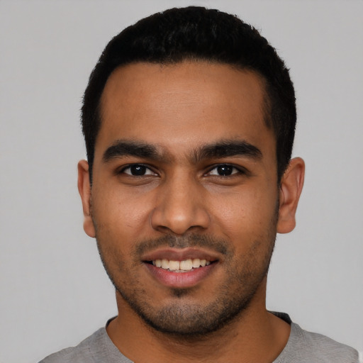 Joyful latino young-adult male with short  black hair and brown eyes