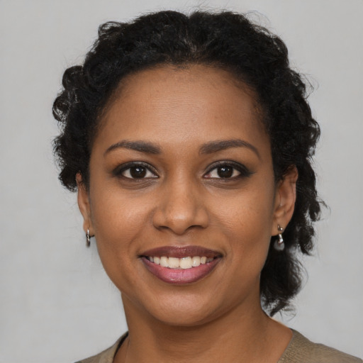 Joyful black young-adult female with medium  brown hair and brown eyes