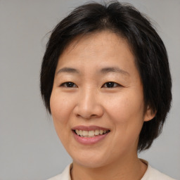 Joyful asian adult female with medium  brown hair and brown eyes