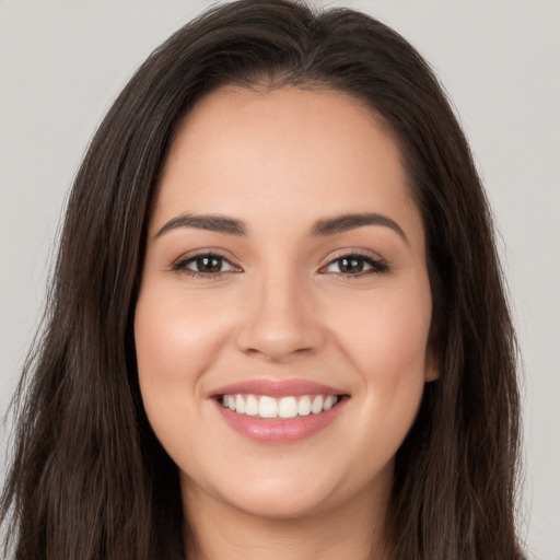 Joyful white young-adult female with long  brown hair and brown eyes