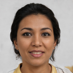 Joyful latino young-adult female with medium  brown hair and brown eyes