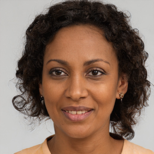 Joyful black young-adult female with medium  brown hair and brown eyes