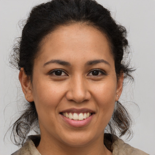 Joyful latino young-adult female with medium  brown hair and brown eyes