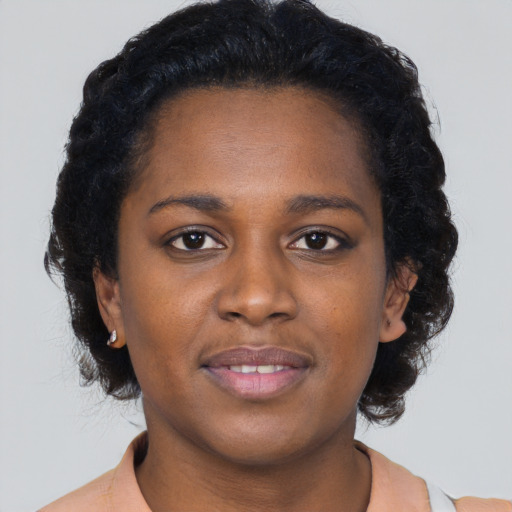 Joyful black young-adult female with short  brown hair and brown eyes