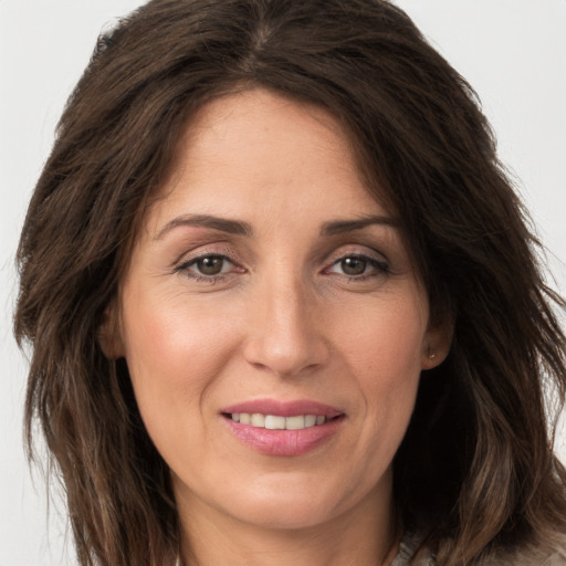 Joyful white adult female with long  brown hair and brown eyes