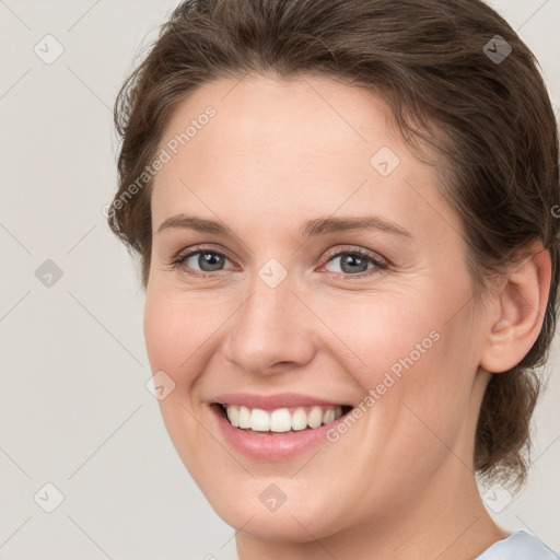 Joyful white young-adult female with medium  brown hair and grey eyes