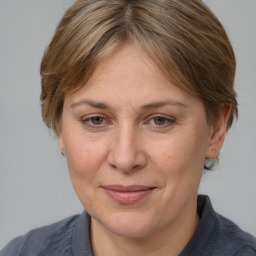 Joyful white adult female with medium  brown hair and blue eyes