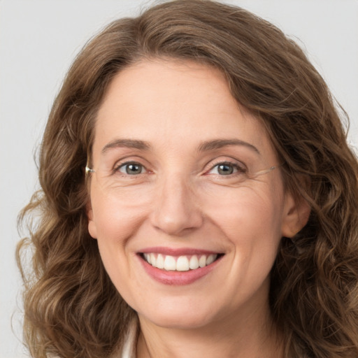 Joyful white adult female with long  brown hair and green eyes