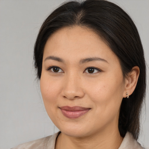 Joyful asian young-adult female with medium  brown hair and brown eyes