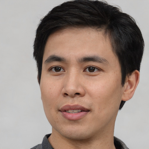 Joyful asian young-adult male with short  black hair and brown eyes