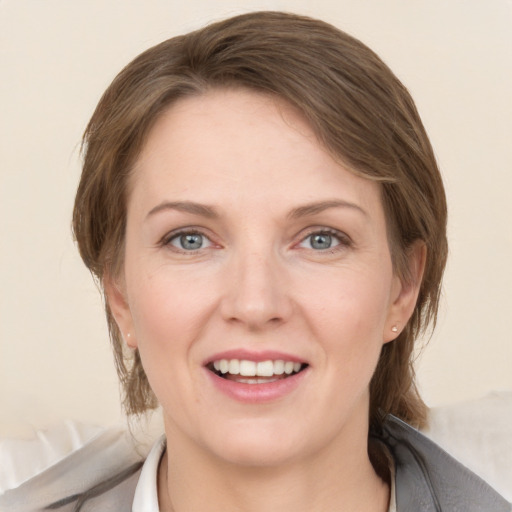 Joyful white young-adult female with medium  brown hair and grey eyes