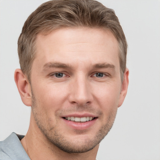 Joyful white young-adult male with short  brown hair and grey eyes