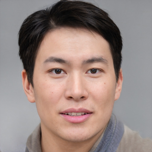 Joyful asian young-adult male with short  brown hair and brown eyes