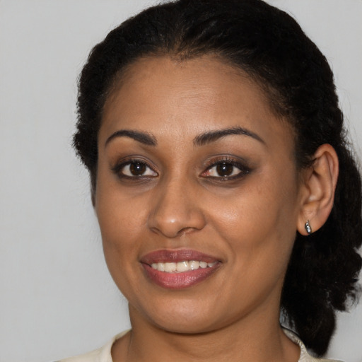 Joyful black young-adult female with medium  brown hair and brown eyes