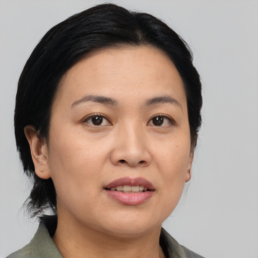 Joyful asian adult female with medium  black hair and brown eyes