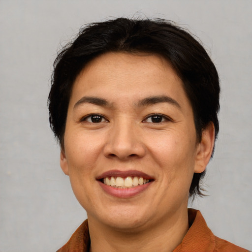 Joyful asian adult female with short  brown hair and brown eyes