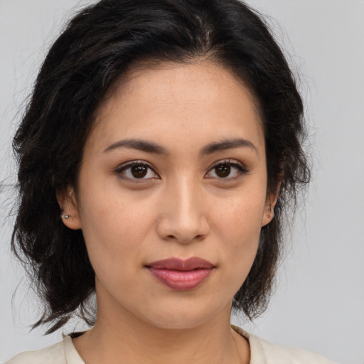 Joyful latino young-adult female with medium  brown hair and brown eyes