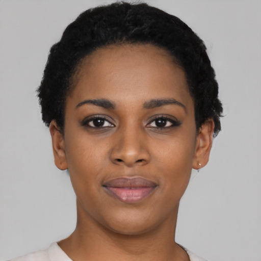 Joyful black young-adult female with short  black hair and brown eyes