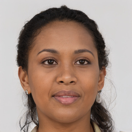 Joyful black adult female with long  brown hair and brown eyes