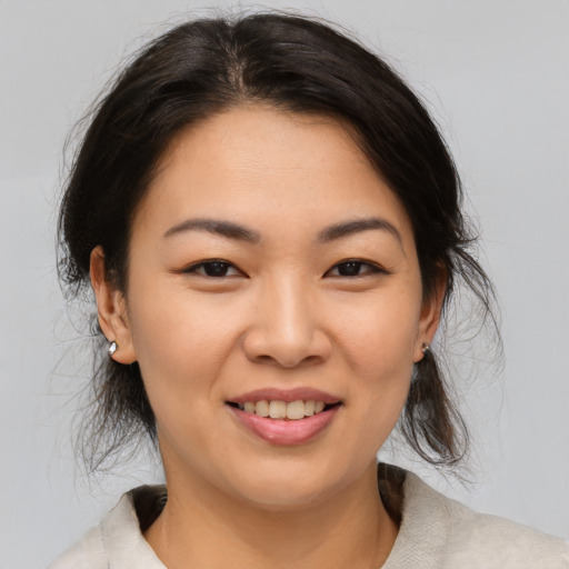 Joyful asian young-adult female with medium  brown hair and brown eyes