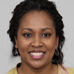 Joyful black adult female with medium  brown hair and brown eyes