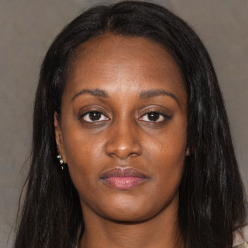 Joyful black young-adult female with long  black hair and brown eyes