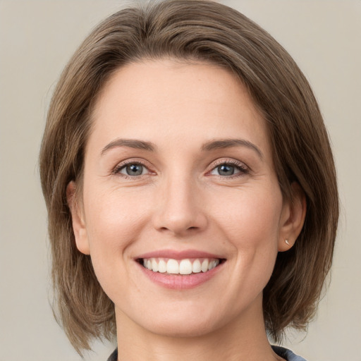 Joyful white young-adult female with medium  brown hair and green eyes