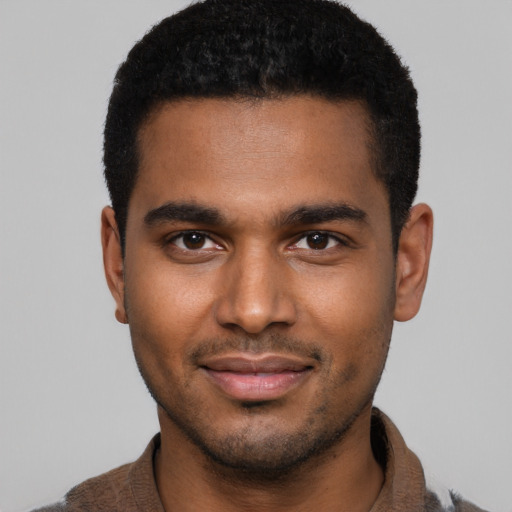 Joyful black young-adult male with short  brown hair and brown eyes