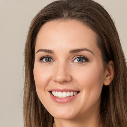 Joyful white young-adult female with long  brown hair and brown eyes