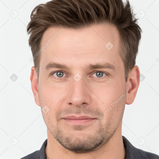 Joyful white young-adult male with short  brown hair and grey eyes