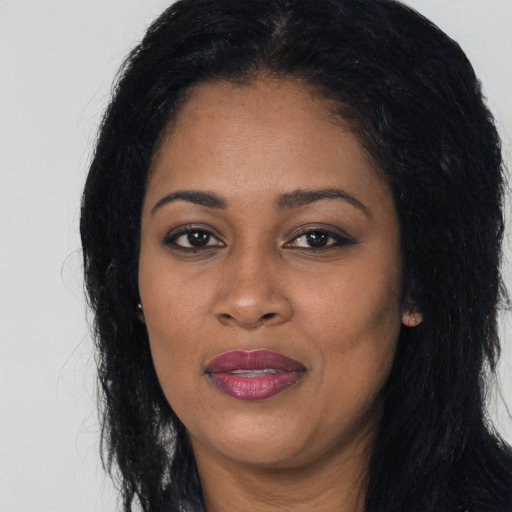 Joyful black young-adult female with long  black hair and brown eyes