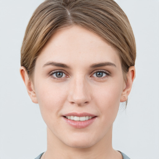 Joyful white young-adult female with short  brown hair and grey eyes