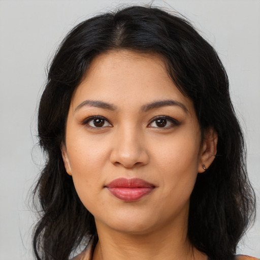 Joyful latino young-adult female with long  brown hair and brown eyes