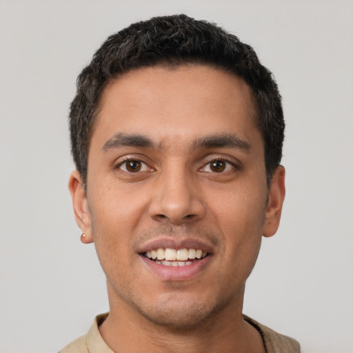 Joyful latino young-adult male with short  black hair and brown eyes