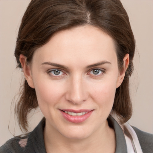 Joyful white young-adult female with medium  brown hair and grey eyes