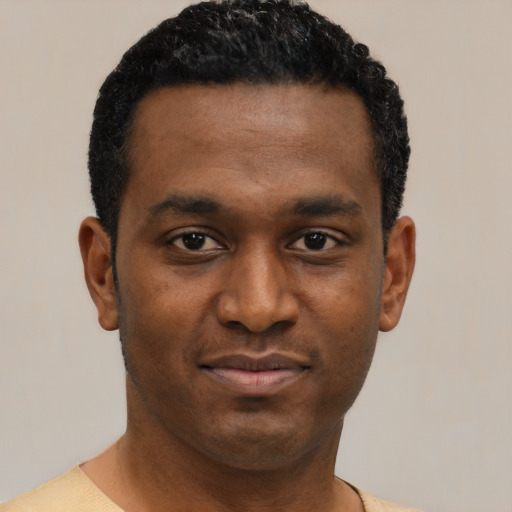 Joyful black young-adult male with short  black hair and brown eyes