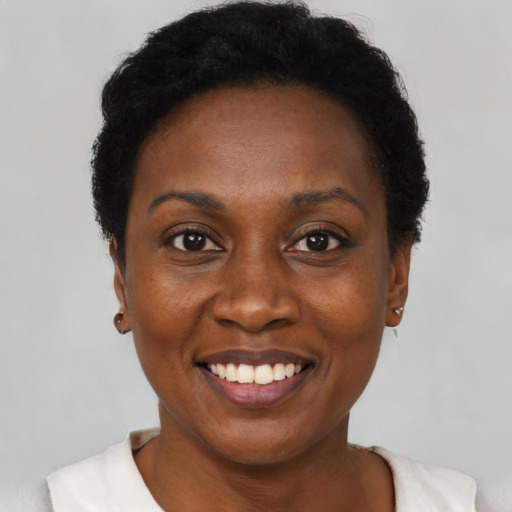 Joyful black adult female with short  black hair and brown eyes