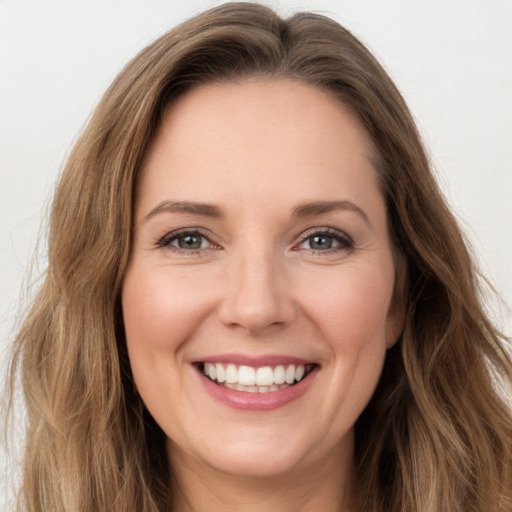 Joyful white young-adult female with long  brown hair and green eyes