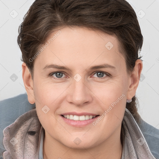 Joyful white young-adult female with short  brown hair and grey eyes