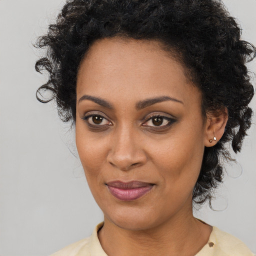 Joyful black young-adult female with long  black hair and brown eyes