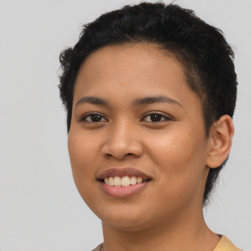 Joyful latino young-adult female with short  black hair and brown eyes