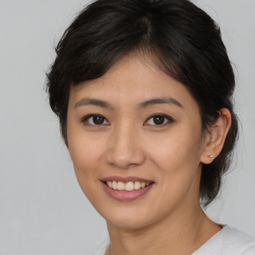 Joyful asian young-adult female with medium  brown hair and brown eyes