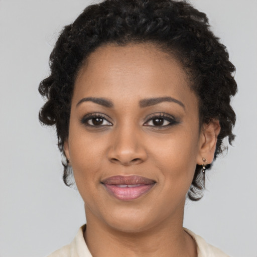 Joyful black young-adult female with short  black hair and brown eyes