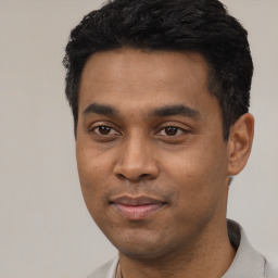 Joyful latino young-adult male with short  black hair and brown eyes