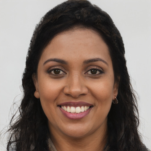Joyful black young-adult female with long  brown hair and brown eyes