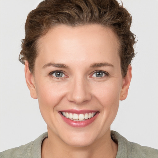 Joyful white young-adult female with short  brown hair and grey eyes