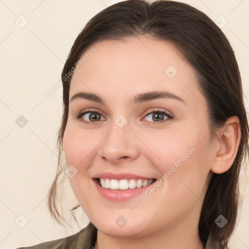 Joyful white young-adult female with long  brown hair and brown eyes