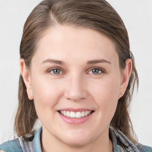 Joyful white young-adult female with medium  brown hair and grey eyes