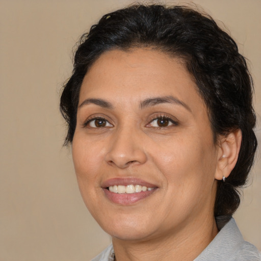 Joyful latino adult female with medium  brown hair and brown eyes