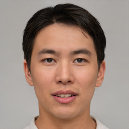 Joyful asian young-adult male with short  brown hair and brown eyes